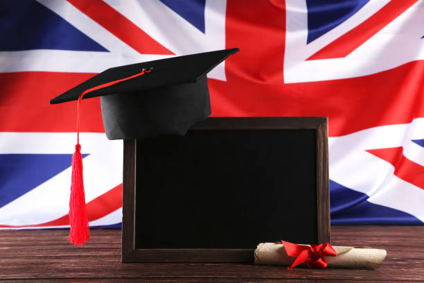 istock Graduation cap with blank frame and diploma on brown wooden table 1140540517