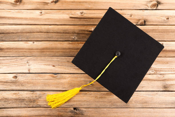 Male hand throwing graduation hat in the air