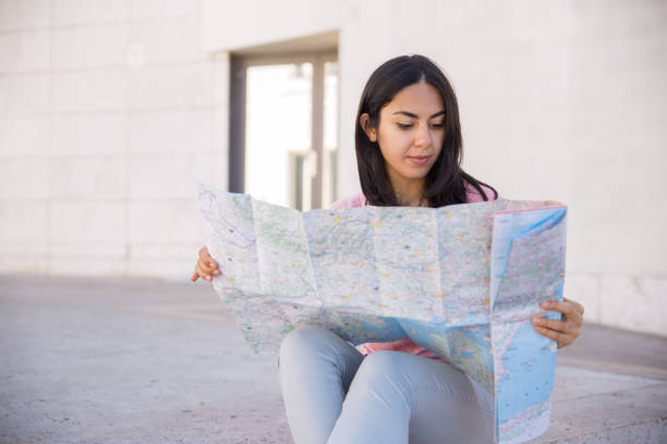 istock Focused young woman studying paper map outdoors 1140544199