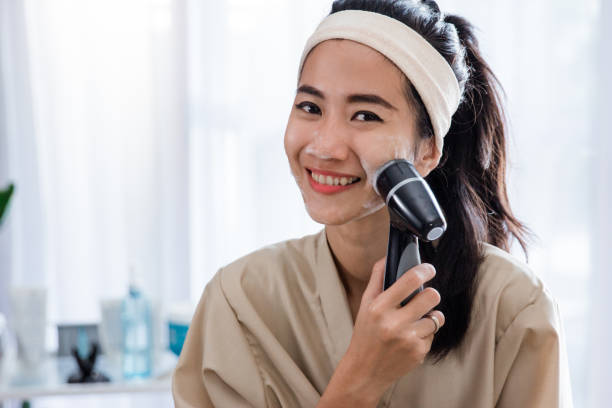 istock woman using electric facial cleanser machine 1140546366