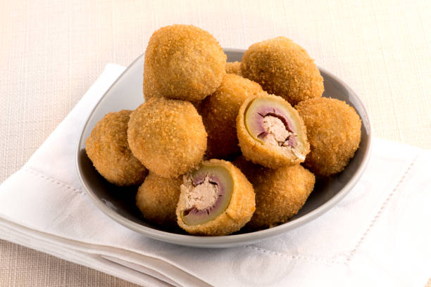 Olive ascolane, or deep fried stuffed olives Olive ascolane, or deep fried breaded stuffed olives with meat filling from the Marche region of Italy served in a bowl with one cut through marche italy photos stock pictures, royalty-free photos & images