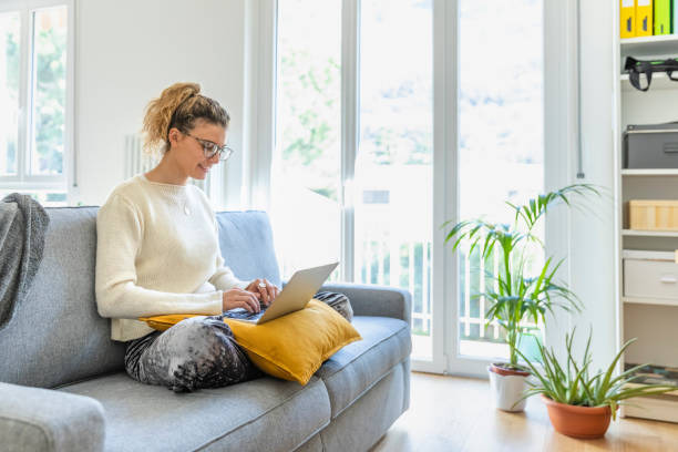 istock Woman surfing the net with laptop on sofa 1140548389