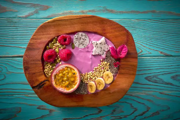 Acai bowl smoothie with passion fruit maracuya seeds banana and raspberries
