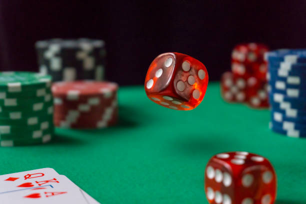 istock Red dice, casino chips, cards on green felt 1140556989