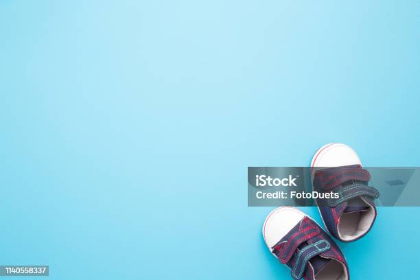 New Jeans Sport Shoes For Little Kid On Pastel Blue Background Baby Footwear Empty Place For Text Quote Sayings Or Logo Stock Photo - Download Image Now