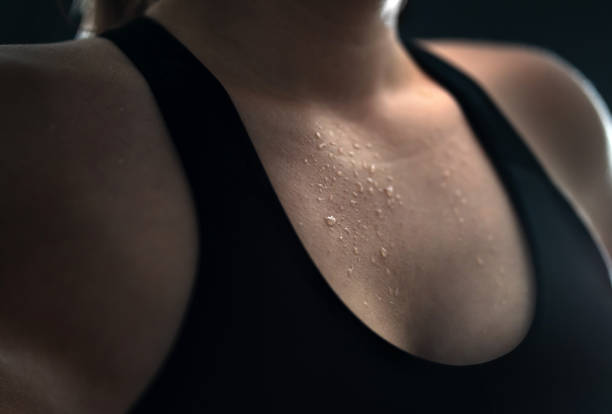 Sweat on skin. Sweaty woman after gym workout, heavy cardio or fat burning training. Yoga instructor, tired fitness athlete or personal trainer. Wet female chest with water drops. Sweat on skin. Sweaty woman after gym workout, heavy cardio or fat burning training. Yoga instructor, tired fitness athlete or personal trainer. Low key close up of wet female chest with water drops. hot women working out pictures stock pictures, royalty-free photos & images