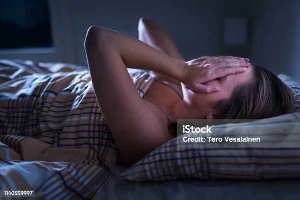 Insomnia Sleep Apnea Or Stress Concept Sleepless Woman Awake And Covering Face In The Middle Of The Night Lady Cant Sleep Nightmares Or Depression Suffering From Headache Stock Photo - Download Image Now