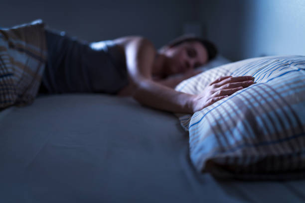 donna single che dorme da sola a letto a casa. signora solitaria scomparsa marito o fidanzato. mano sul cuscino. solitudine, infedeltà o concetto di crepacuore. solitudine e dolore dopo la rottura. - solitude loneliness bedroom empty foto e immagini stock