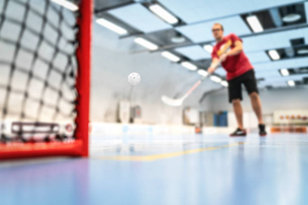floorball utbildning på domstol. man tränar golv hockey i arenan. skott på mål. - innebandy bildbanksfoton och bilder