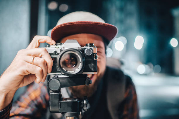 hombre tomando foto en la cámara de película vintage - fotógrafo fotografías e imágenes de stock