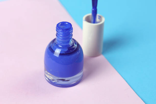 Blue nail lacquer  polish bottle and nail brushes on pink background.  Nail service manicure
