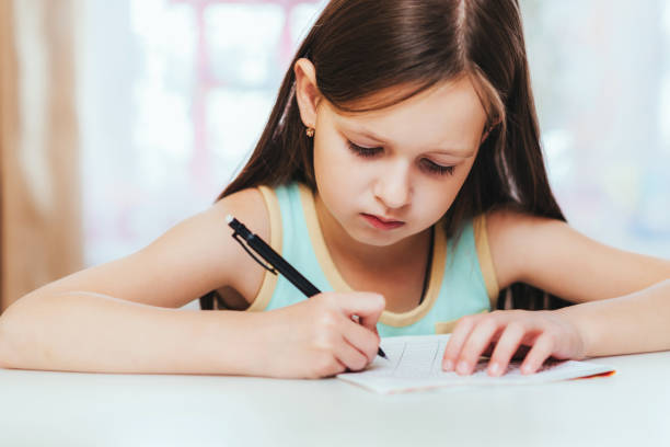 istock the girl is a first grader in the room doing homework 1140562945