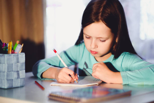 istock the girl is a first grader in the room doing homework 1140563005