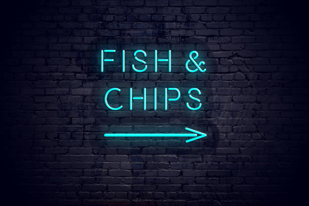 Brick wall with neon arrow and sign fish chips. stock photo