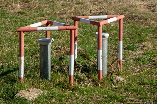 Groundwater measuring points with steel protection tube, end cap with hex locking and red and white concreted protection triangle, drill