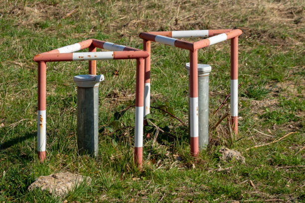 groundwater measuring points with steel protection tube, end cap with hex locking and red and white concreted protection triangle - groundwater imagens e fotografias de stock