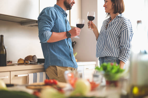 istock Beautiful loving couple enjoying alcohol drinks in kitchen 1140564035