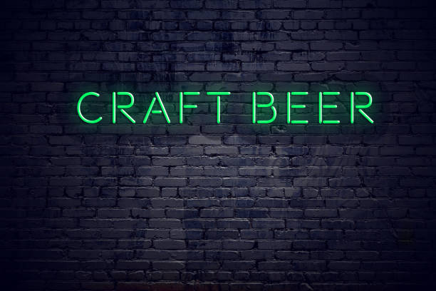 Brick wall at night with neon sign craft beer stock photo