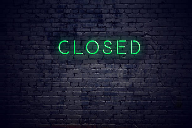 Brick wall at night with neon sign closed stock photo