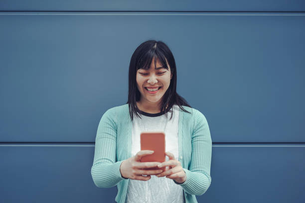 Happy Chinese girl using mobile phone outdoor - Asian woman having fun with new trends smartphone apps - Generation z, media, technology and youth millennial people lifestyle chica china feliz usando teléfono móvil al aire libre-mujer asiática que se divierte con las nuevas tendencias aplicaciones de teléfonos inteligentes-generación z, medios de comunicación, tecnología y estilo de vida de las personas jóvenes milenari