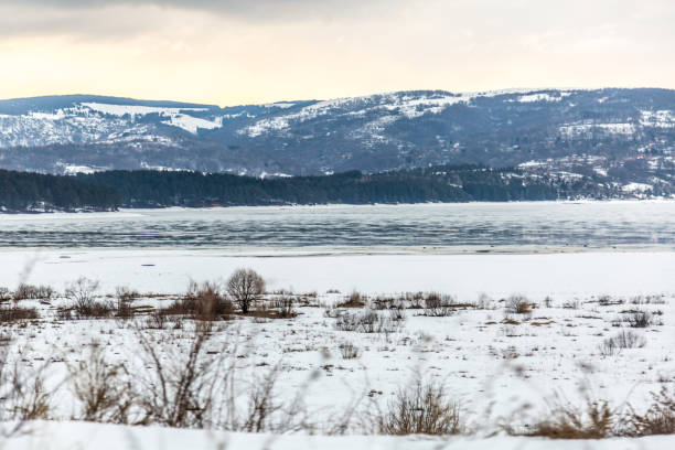 istock Colorful landscape with snowy trees, river with reflection in water in cold evening 1140569169