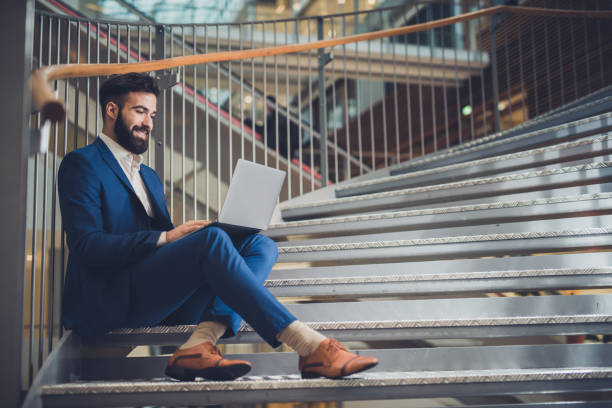 istock Handsome businessman in suit working on laptop. 1140571340