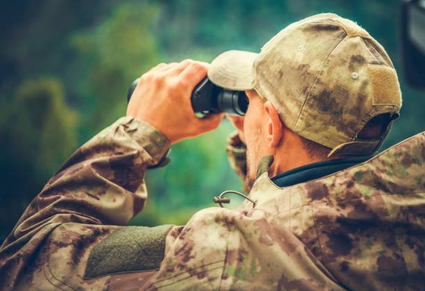 Spotting Game Using Binoculars Caucasian Hunter Spotting Game Using Binoculars. Hunting Season. hunting sport stock pictures, royalty-free photos & images