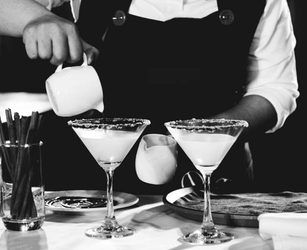 Bartender making alcohol cocktail at bar counter at nightclub, barman is making cocktail