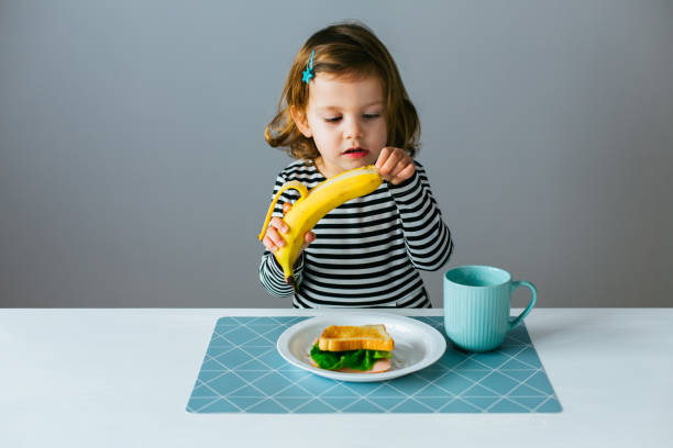 Little girl eating banana