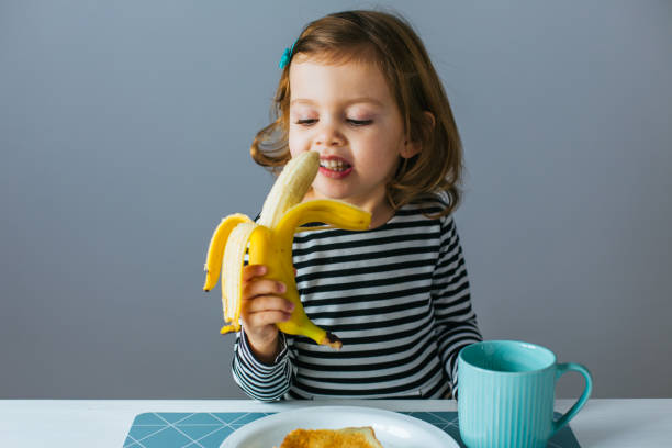 Little girl eating banana
