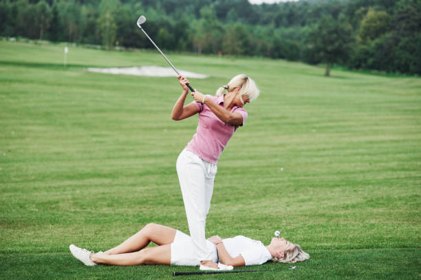 두 여자는 골프를 조금 다른 방법으로 재생 하기로 결정 합니다. 이 시도는 자신의 위험에 - golf women female concentration 뉴스 사진 이미지