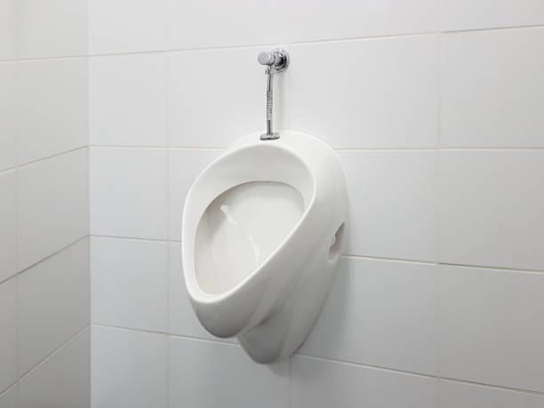 istock The bathroom interior is lined with white ceramic tiles. Oval ceramic urinal. Public place for coping needs. Ceramic household product. Saving running water in everyday life. Restroom Design Solution 1140578073