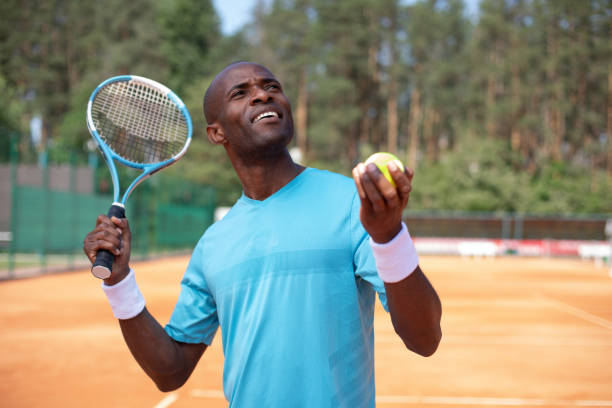 istock Positive guy is playing tennis in open air 1140580669
