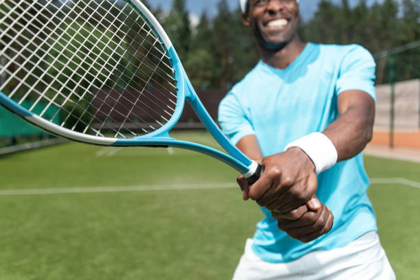 istock Smiling man is going to hit ball during tennis match 1140581020
