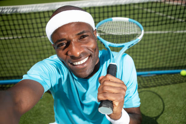 Jolly tennis player is resting on playground