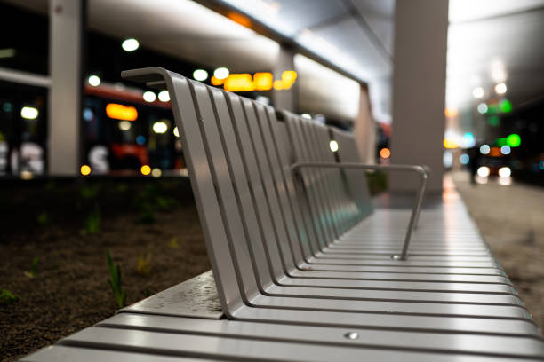 A bench / seat in the bus and train station, public transport hub in the city center of Tilburg, Noord Brabant, Netherlands. A bus stands still on the background. A seat for people to sit on. berkel stock pictures, royalty-free photos & images