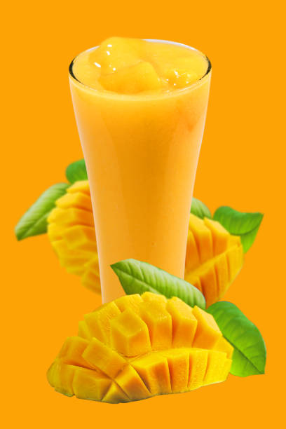 istock Mango smoothie in high glass served with slides mangoes on orange background. Mango shake shooting in studio. Image with path. Organic tropical fruits on summer concept. 1140583845