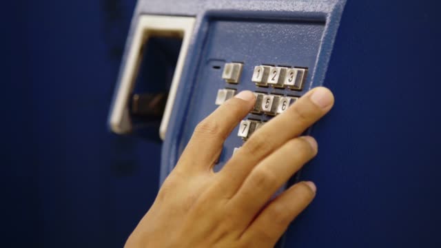 Closeup Hand of Woman Using Public Telephone or Phone Booth Station.