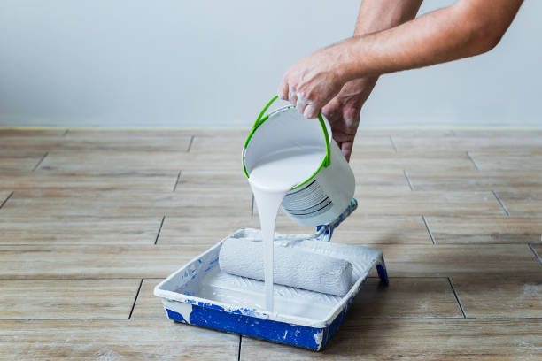 istock Hands pouring color paint into paint tray 1140588309
