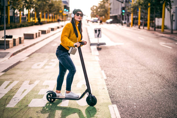 una mujer urbana escuchando música a través de los auriculares que buscan unirse al tráfico en la calle del centro de la ciudad - boulevard fotografías e imágenes de stock