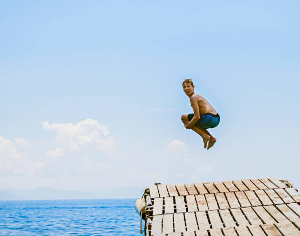istock Boy Jumping Into The Sea 1140590396