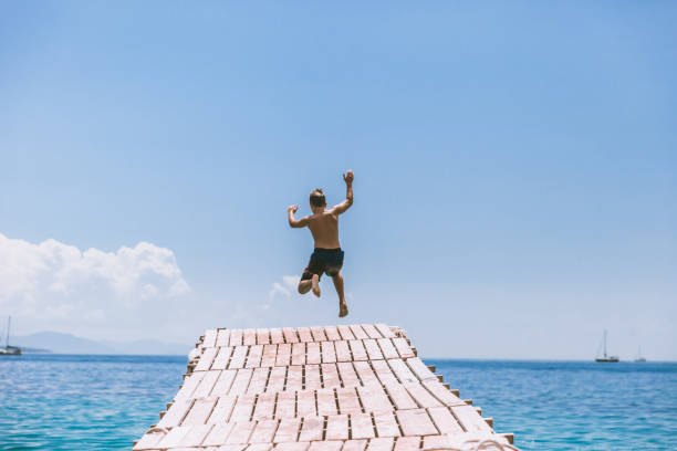 istock Boy Jumping Into The Sea 1140590422