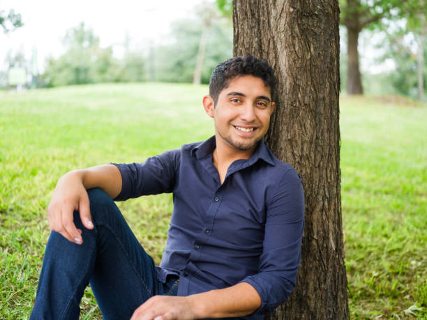 istock Happy young man sitting outdoors and smiling 1140590726