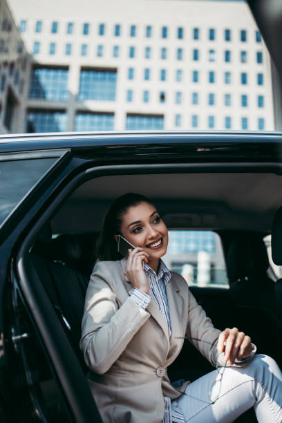 молодая бизнес-женщина в машине - luxury car women smart phone стоковые фото и изображения