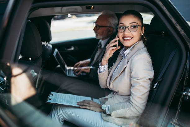 деловые люди в автомобиле - luxury car women smart phone стоковые фото и изображения