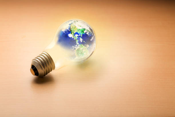 istock Light bulb with the world on wooden background 1140596140