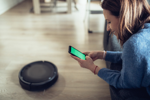 Woman Using Home Robot Cleaning App