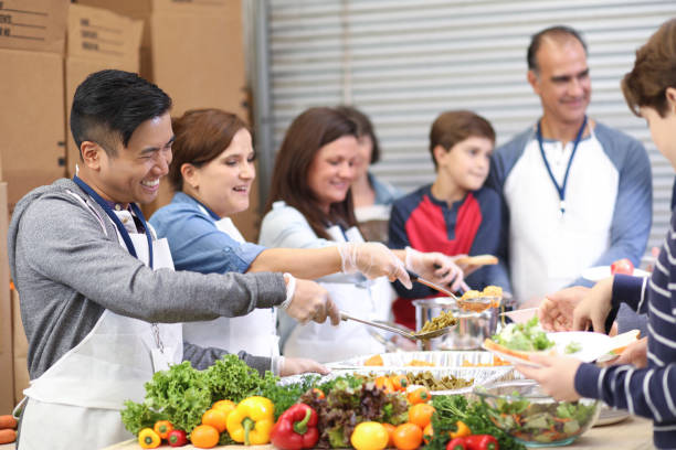 istock Multi-ethnic group of volunteers serves food at soup kitchen. 1140596684
