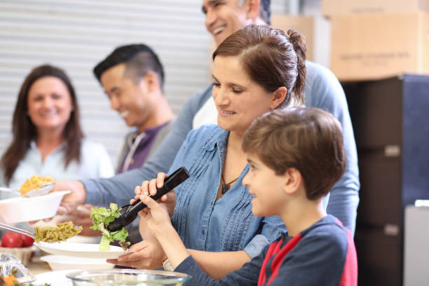 istock Multi-ethnic group of volunteers serves food at soup kitchen. 1140596784