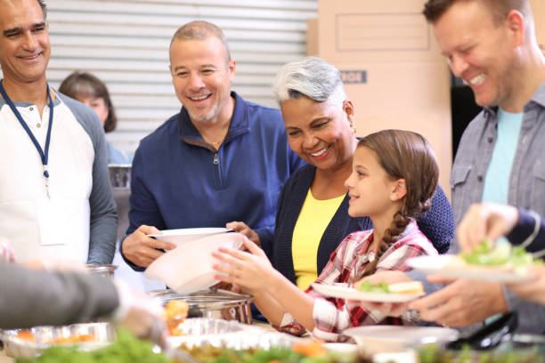 istock Multi-ethnic group of volunteers serves food at soup kitchen. 1140596841